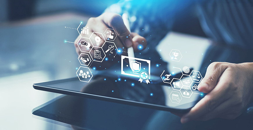 IT-Zertifikate: Zwei Hände halten ein Tablet, über dem Symbole für Zertifikate und digitale Auszeichnungen schweben