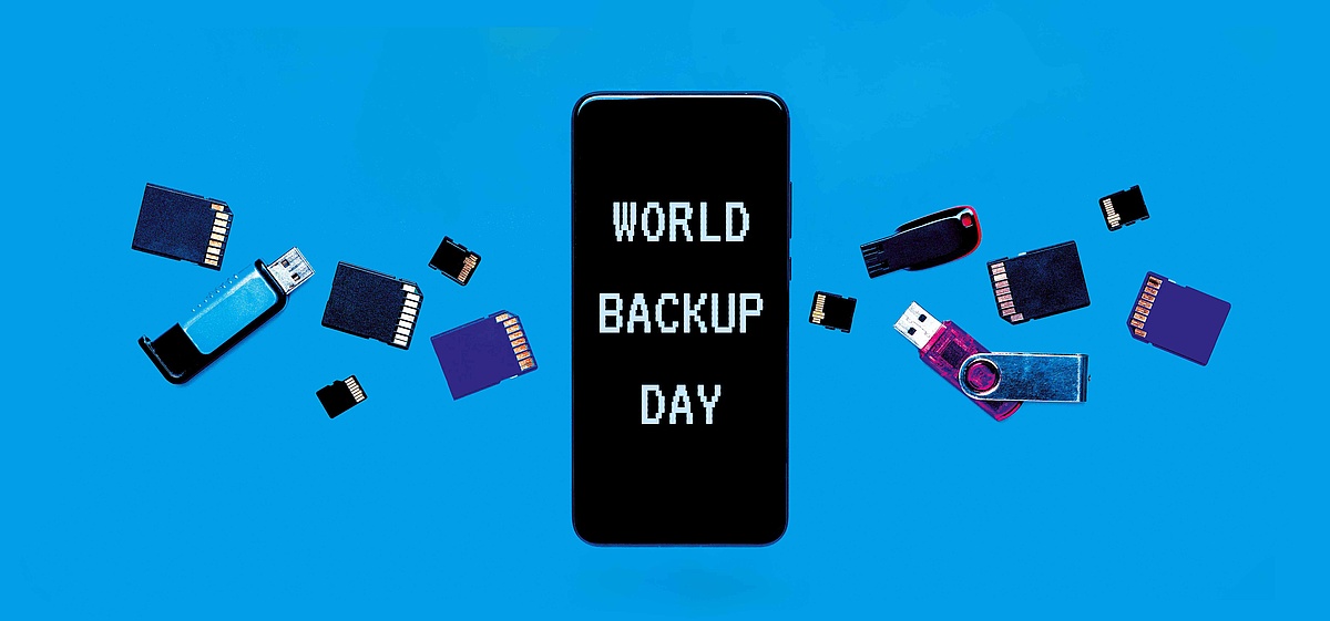 Abbildung zum "World Backup Day" mit einer zentralen Darstellung eines Mobiltelefons, das von verschiedenen Speichergeräten wie USB-Sticks und Speicherkarten umgeben ist